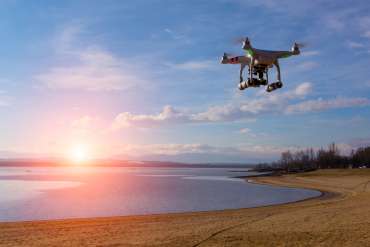 A drone overlooks the beach at sunset, capturing drone footage for a video production.