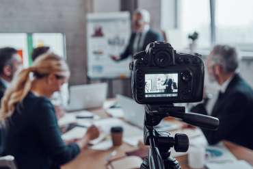 Business team holding a strategy meeting while filming content for video campaigns.