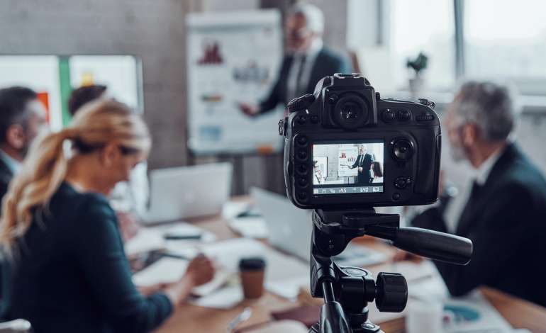 Business team holding a strategy meeting while filming content for video campaigns.