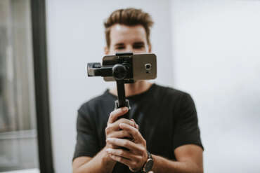 Man holding a gimbal attached to a smartphone.