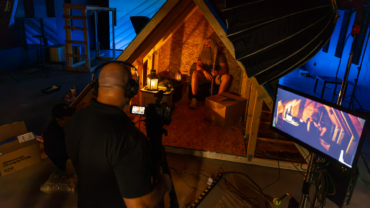 Production crew filming a commercial on a custom attic set inside a professional studio