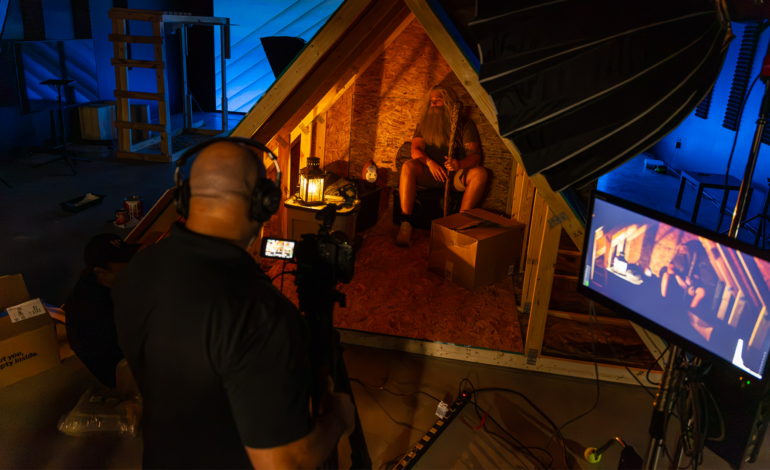 Production crew filming a commercial on a custom attic set inside a professional studio